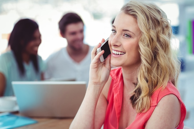 Femme d&#39;affaires créative souriante travaillant avec des collègues