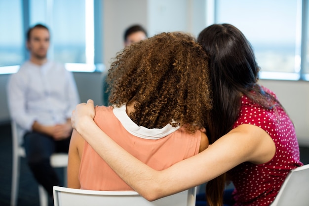 Femme d'affaires créative vue arrière s'embrassant au bureau