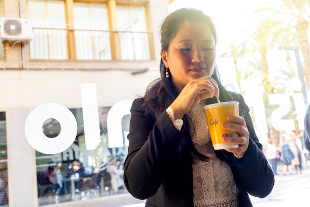 Femme d'affaires dans un coup rétro-éclairé en buvant du café dans un bar