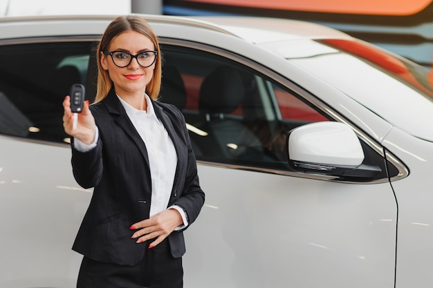 Femme d'affaires dans la salle d'exposition de voiture