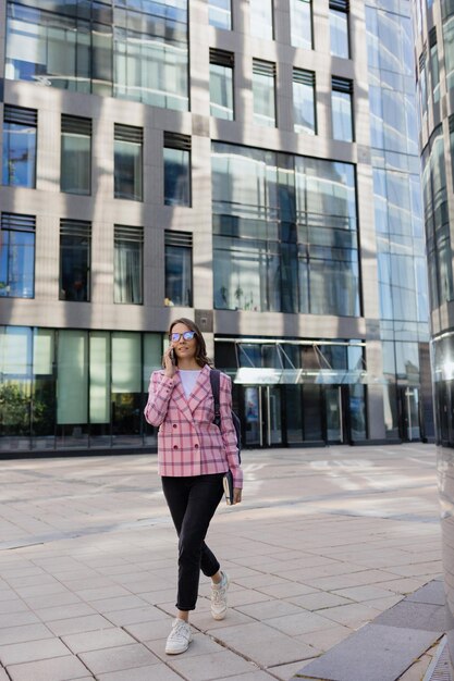 Photo femme d'affaires dans une veste rose va travailler au bureau et sourit une femme entrepreneur européenne confiante et prospère