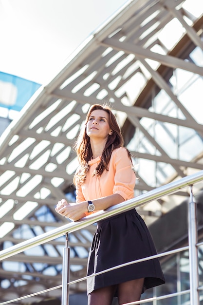 Femme d'affaires debout sur le balcon du bureau moderne