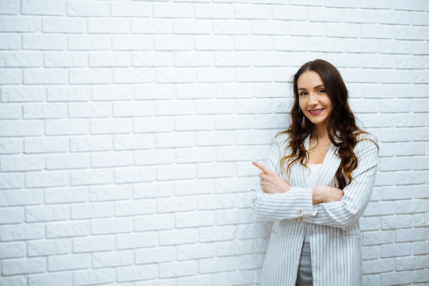 Femme affaires, debout, blanc, brique, mur