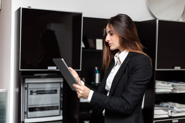 Femme affaires, debout, bureau, tenue, numérique, tablette