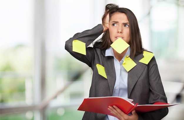 Femme d'affaires debout avec cahier et notes autocollantes