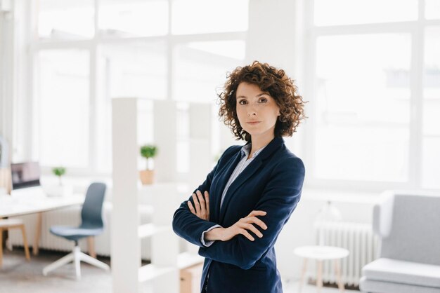 Femme d'affaires debout dans son bureau avec les bras croisés