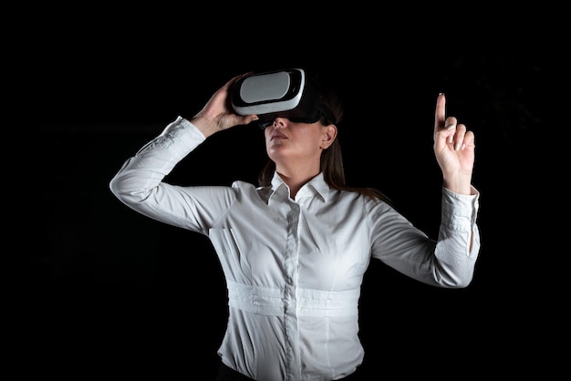 Femme d'affaires debout et gesticulant tout en apprenant des compétences professionnelles grâce à un simulateur de réalité virtuelle Femme élégante présentant des techniques de formation modernes