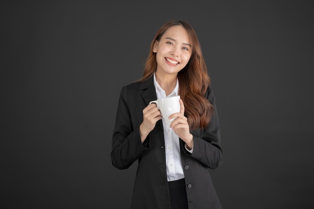 Femme d'affaires debout avec une tasse de café blanche en chemise blanche