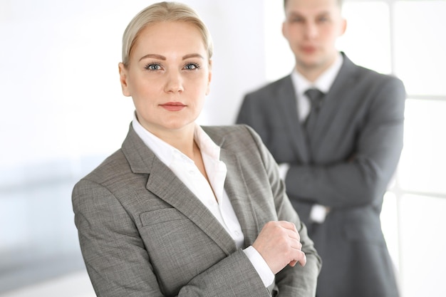 Femme d'affaires debout tout droit avec un collègue homme d'affaires au bureau, photo dans la tête. Concept de succès et de partenariat d'entreprise.