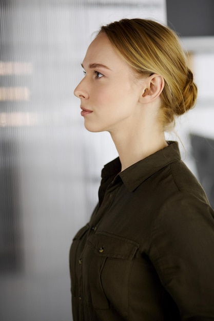 Femme d'affaires décontractée adulte amicale ou étudiante debout droit. Photo d'entreprise ou portrait au bureau.