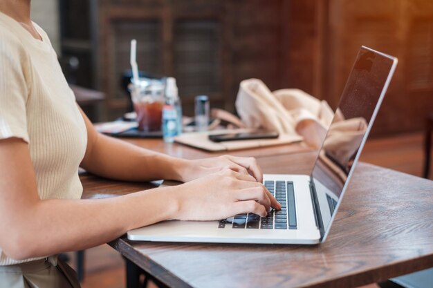 Femme d'affaires décontractée à l'aide d'un ordinateur portable femme indépendante tapant clavier ordinateur portable dans un café ou une technologie de bureau moderne numérique en ligne et concept de réseau