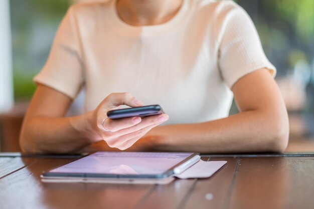 Femme d'affaires décontractée tenant et utilisant un smartphone pour les messages sms jeune femme tapant un téléphone portable à écran tactile dans un café ou une technologie de style de vie de bureau moderne Concept de médias sociaux et de réseau