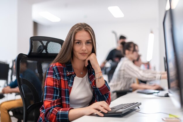 Femme d'affaires décontractée travaillant sur un ordinateur de bureau dans un intérieur de bureau de démarrage à aire ouverte moderne. Mise au point sélective. Photo de haute qualité