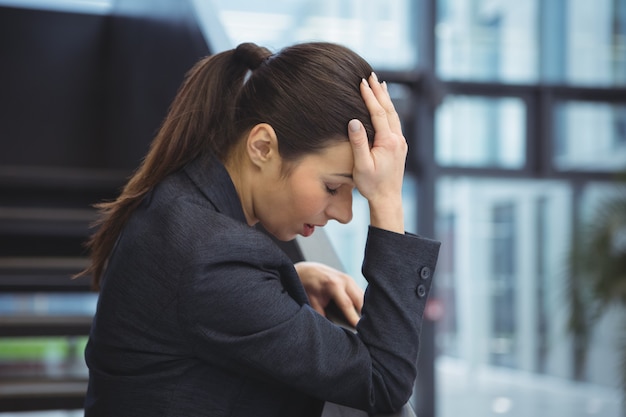 Femme d'affaires déprimée avec la main sur sa tête