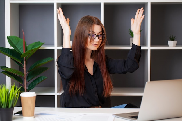 Femme d'affaires détendue travaillant avec un ordinateur portable dans son bureau