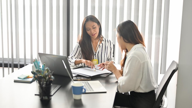 Femme d'affaires discutant du projet avec un collègue, remue-méninges, partageant des idées lors de la réunion privée