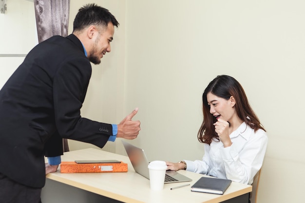 Photo une femme d'affaires discute avec un collègue en utilisant un ordinateur portable à table.