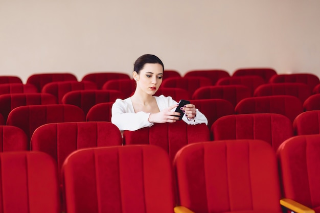 Femme d&#39;affaires avec des documents et téléphone assis sur une chaise de sièges