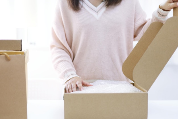 Femme d'affaires à domicile préparant une boîte de livraison de colis Expédition pour faire des achats en ligne jeune propriétaire de petite entreprise à domicile