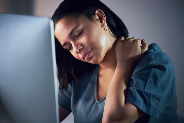 Femme d'affaires douleur au cou et nuit dans le stress épuisement ou fatigue par l'ordinateur au bureau Frustrée surmenée et fatiguée femme avec douleurs musculaires de l'épaule ou tension travaillant tard sur le lieu de travail