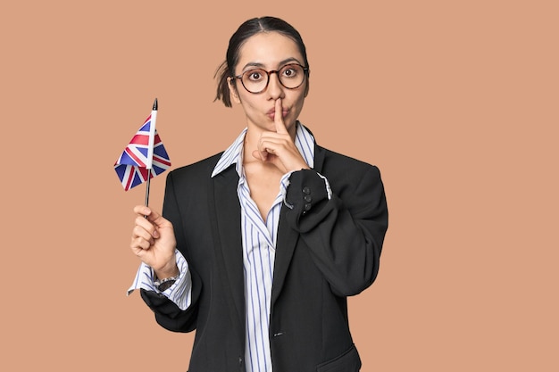 Une femme d'affaires avec un drapeau britannique symbolisant les affaires internationales sur le fond du studio