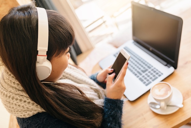 Femme d'affaires écoutant de la musique dans le café. Concept d'entreprise