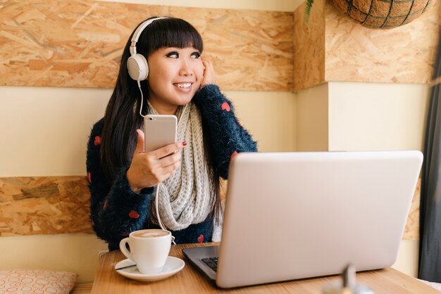 Femme d'affaires écoutant de la musique dans le café. Concept d'entreprise