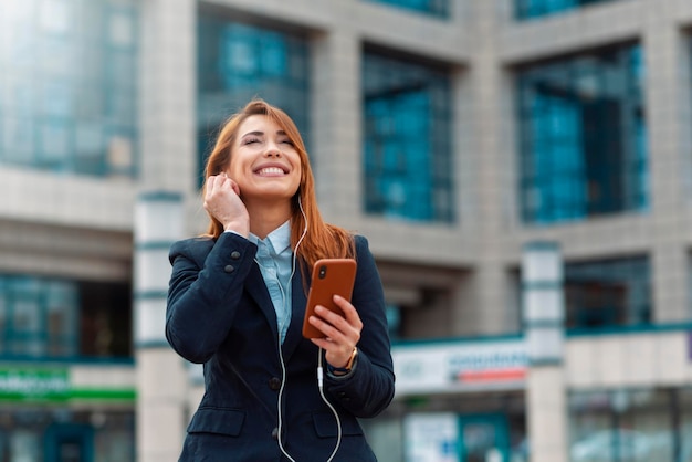 La femme d'affaires écoute la musique extérieure