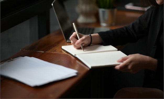 Femme d&#39;affaires écrit sur un cahier