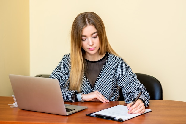 Femme d'affaires écrit sur un document