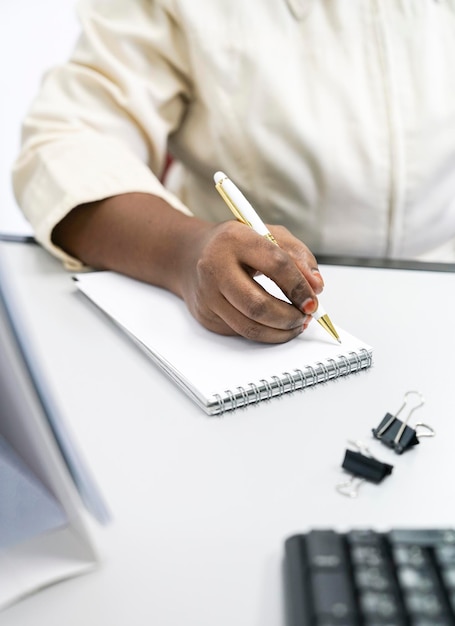 Femme d'affaires écrivant sur un bloc-notes