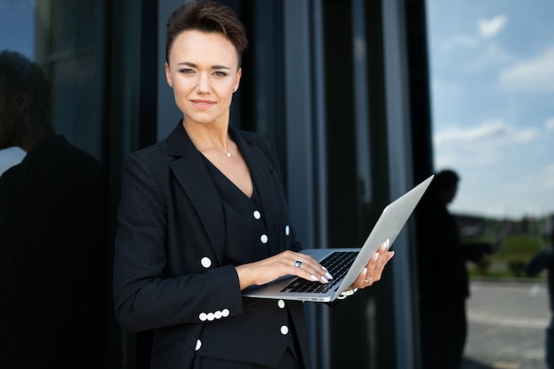 Femme d'affaires élégant sur l'arrière-plan d'un immeuble à la mode de bureau