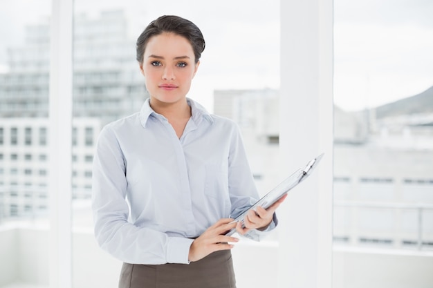 Femme d&#39;affaires élégant avec le presse-papier dans le bureau