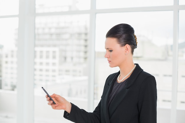 Femme d&#39;affaires élégant en regardant téléphone portable