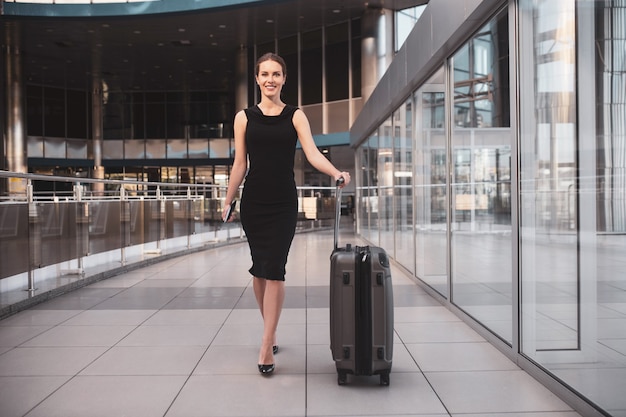 Femme d'affaires élégante avec des bagages à l'aéroport