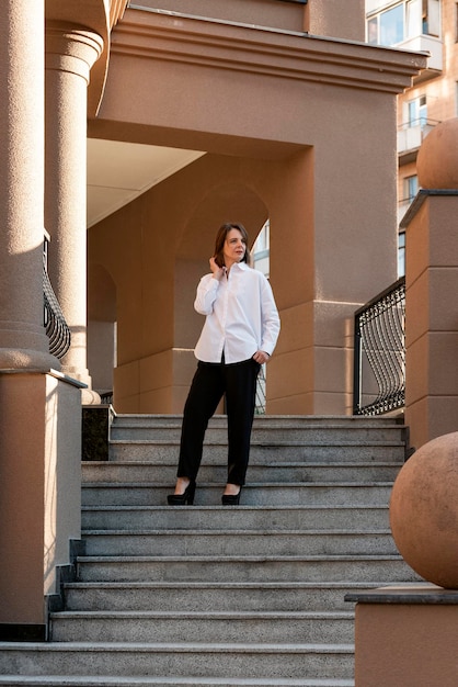 Femme d'affaires élégante dans les escaliers d'un immeuble moderne