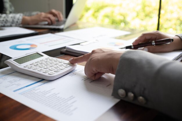 Photo une femme d'affaires entrepreneur comptable travaillant sur un rapport financier sur son bureau à l'aide d'un ordinateur portable calculateur