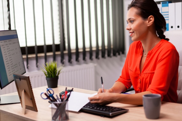 Femme d'affaires entrepreneur préparant une présentation financière en regardant des graphiques d'analyse. Auditeur financier réussi dans le marketing de données en regardant des graphiques sur écran d'ordinateur et en rédigeant un rapport.