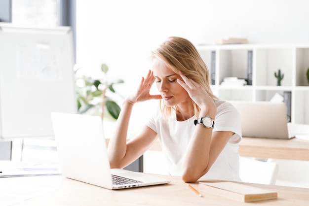 Femme d'affaires épuisée travaillant sur un ordinateur portable