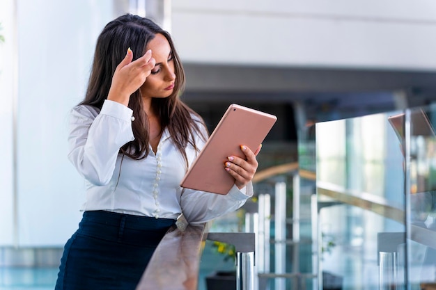 Femme d'affaires espagnole Une femme d'affaires fatiguée consulte des données sur une tablette