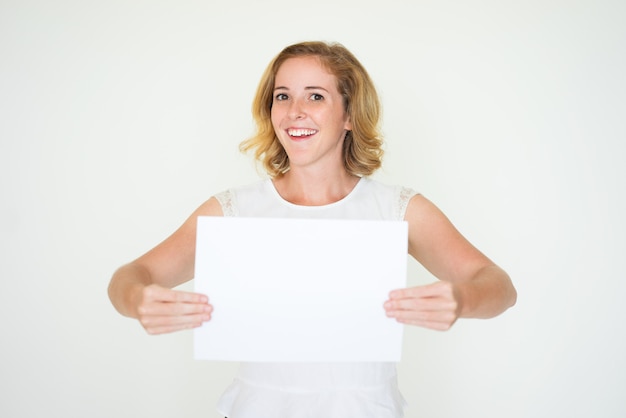 Photo femme d'affaires excité gai montrant le papier blanc