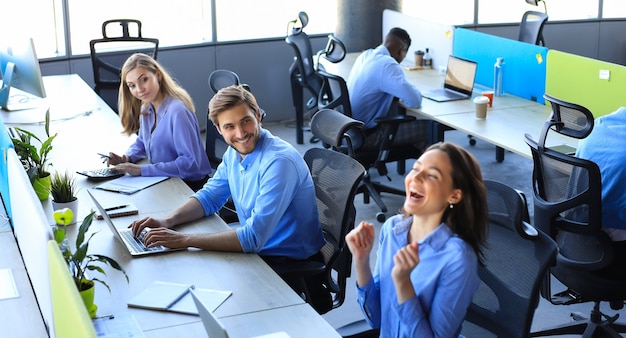 Femme d'affaires excitée regardant un ordinateur portable célébrant le succès en ligne assis au bureau. Femme lisant de bonnes nouvelles par e-mail.