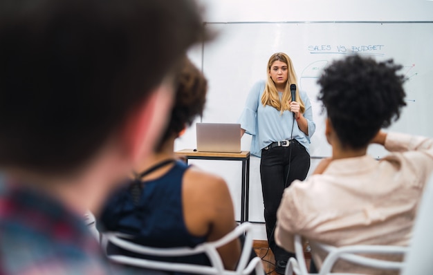 Femme d'affaires expliquant le plan de travail en conférence.