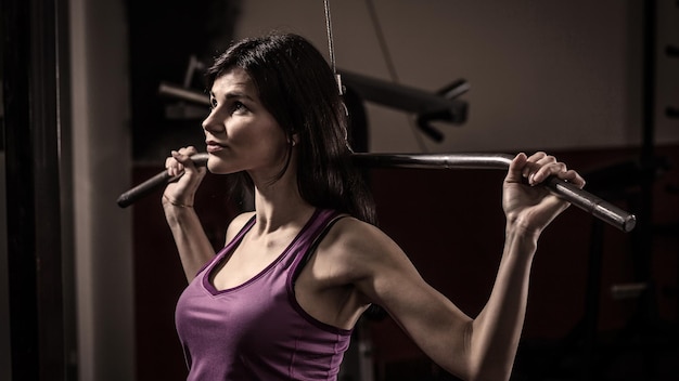 Femme d'affaires faisant de l'exercice sur une machine de fitness dans un club de fitness