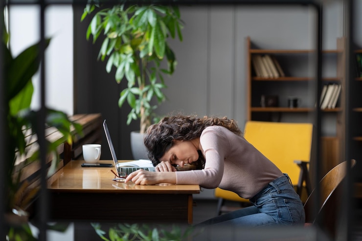 Photo une femme d'affaires fatiguée dormant sur son bureau au bureau, épuisée, démotivée par des tâches monotones, a besoin de repos.