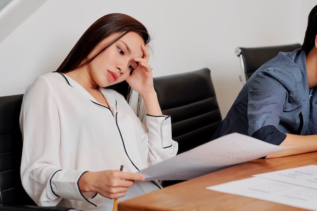 Femme d'affaires fatiguée travaillant avec des documents