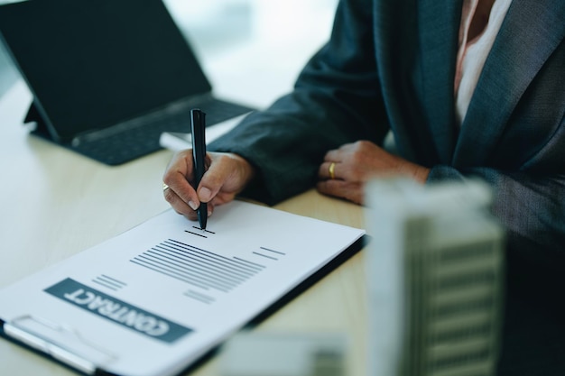 Une femme d'affaires ou une femme propriétaire d'entreprise signe des documents importants pour emprunter de l'argent pour investir dans l'immobilier ou les maisons avec la banque