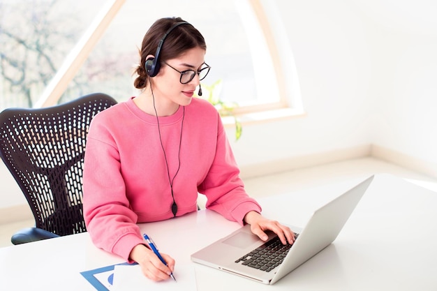 Femme d'affaires financière ayant une réunion en ligne assise à son bureau à la maison