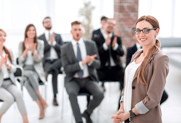 Femme d'affaires sur fond flou d'auditeurs dans la salle de conférence