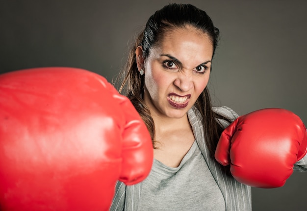 Femme d'affaires avec des gants de boxe rouges